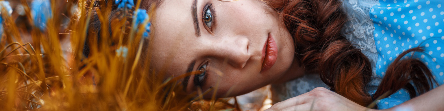 Foto van een dame tussen de korenbloemen liggend